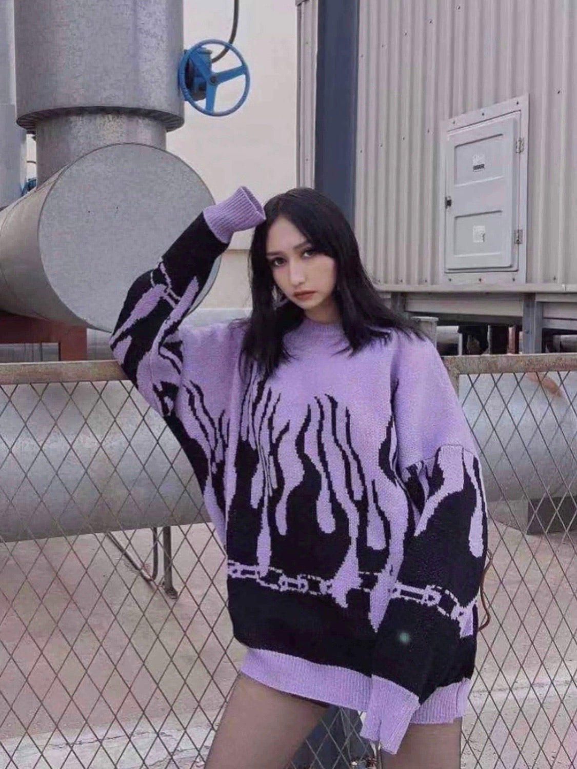 purple knitted sweater with black flames starting from the bottom of the sweater and the wrists worn by a woman