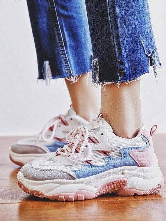 pink, grey, blue and white sneakers at the feet of a mannequin