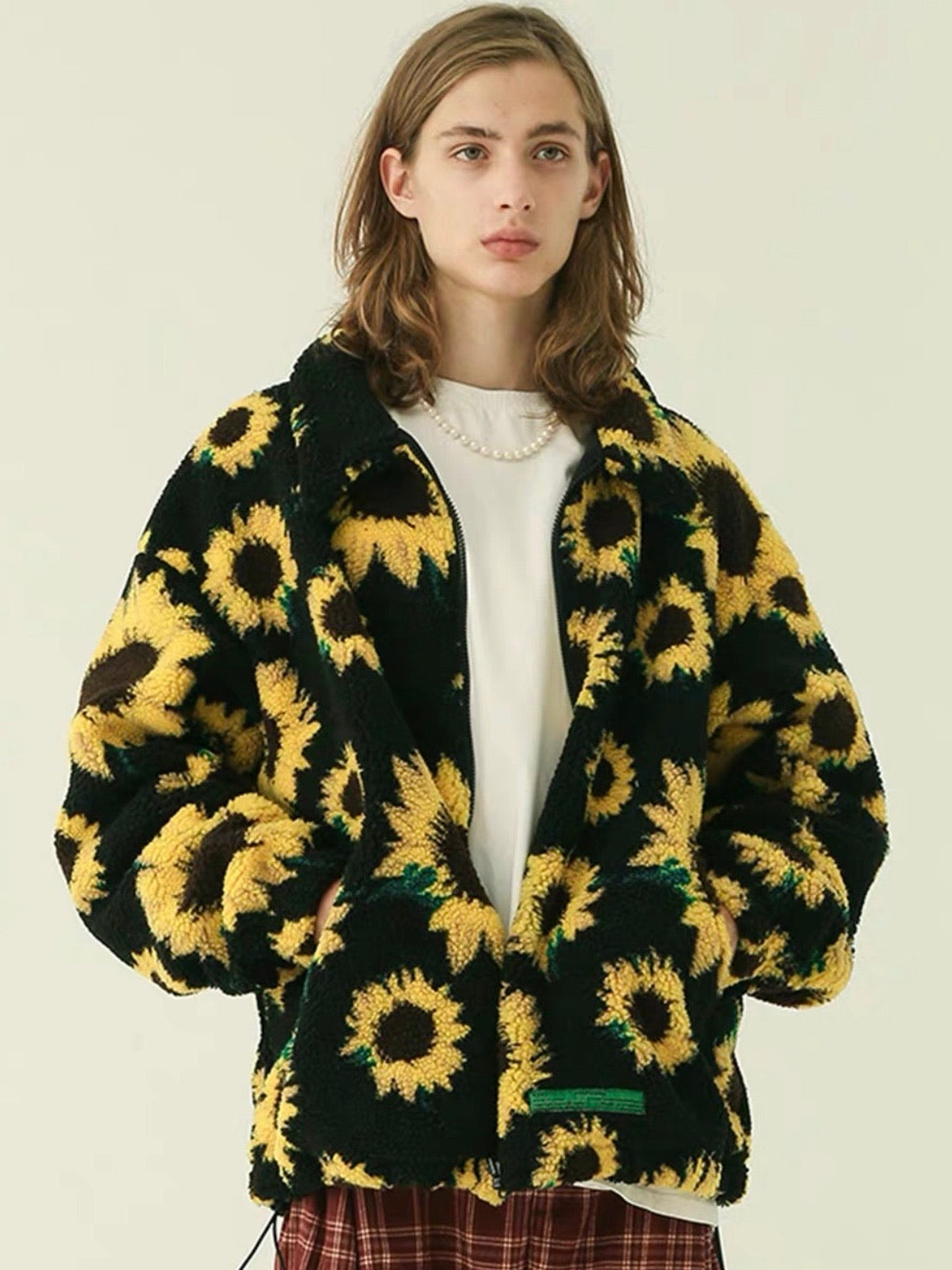 warm jacket with two front pockets and sunflowers printed on a plain black background worn