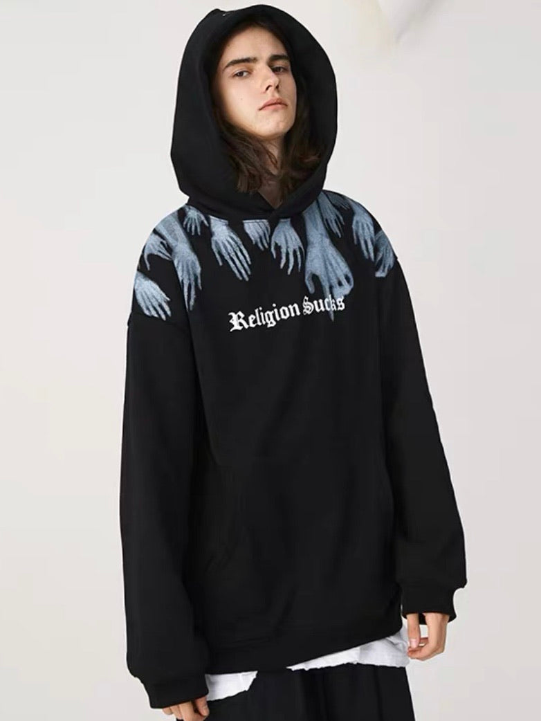 black hoodie with a front pocket, religion sucks written in white on the chest in gothic letters with x-ray hands leaving from the top of the sweater worn by a man