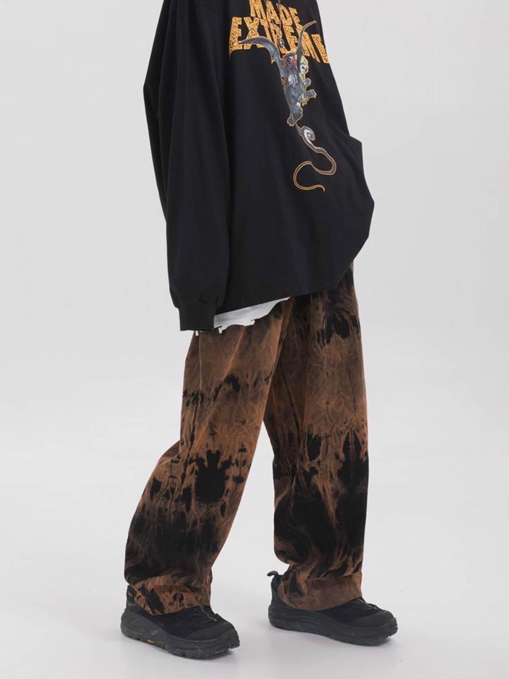 brown tie and dye velvet long pants vh studios with made extreme embroidered in white on the top of the left thigh. t has an elastic waist adjustable with a black  lace