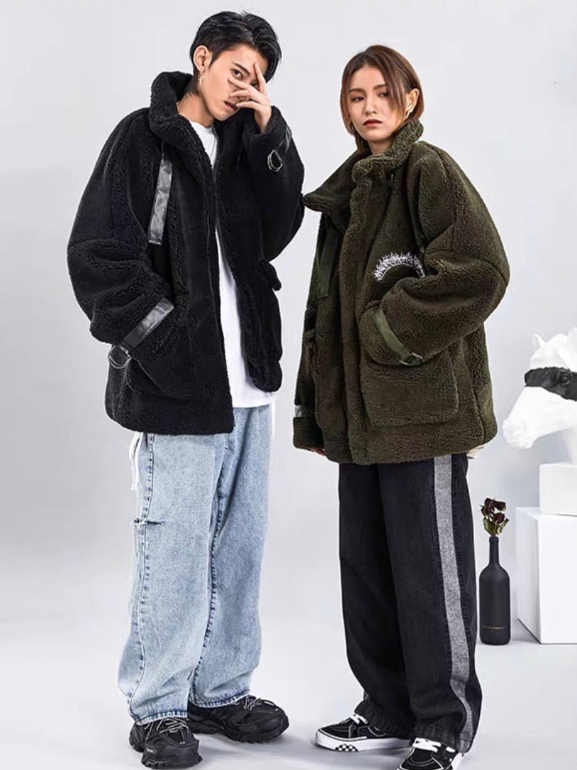 thick fluffy black oversized jacket with simili cuir straps the neck and wrists worn by a man and thick fluffy green oversized jacket with simili cuir straps the neck and wrists worn by a woman